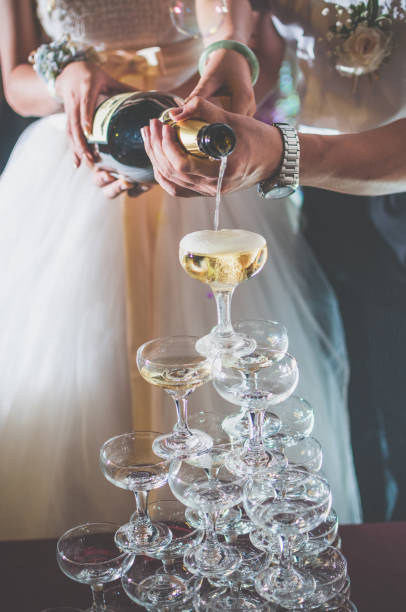 A bride and brideroom holding a bottle of Champagne for celebrate wedding.